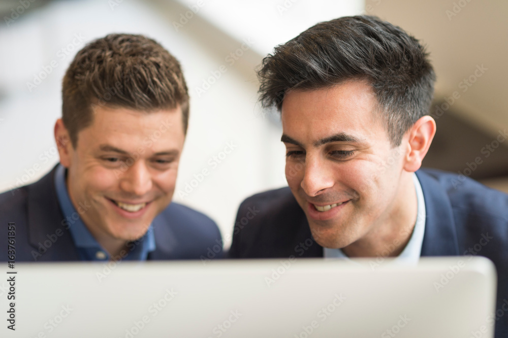 Two businessmen looking at computer in office Two businessmen looking at computer in office