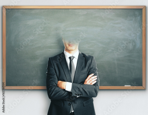 Headless businessman on blackboard background