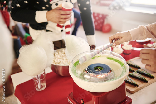 Cropped shot of young woman preparing candyfloss at christmas party photo