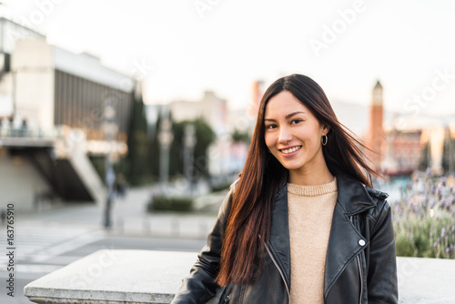 Korean young woman close-up looking at the camera smiling and happy enjoying the views