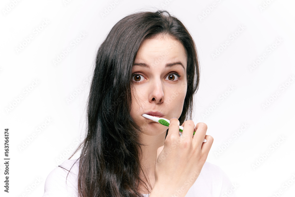 Beautiful young woman on white isolated background brushes teeth Beautiful young woman on white isolated background brushes teeth