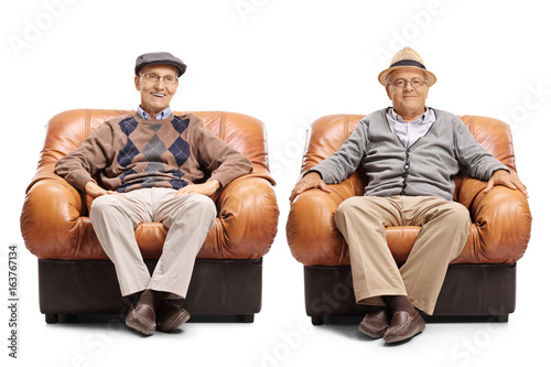 Two elderly men sitting in leather armchairs