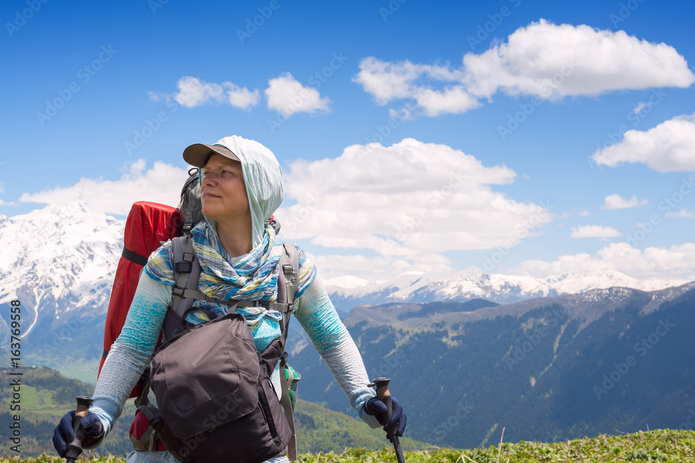 Portrait of woman traveler who stands on the mountain plateau