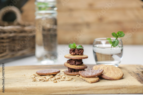 wholewheat and chocolate buscuits stacked with chocolate nut butter and minted water