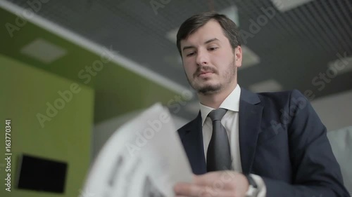 Handsome businessman reads a newspaper and wait boarding on the plane photo