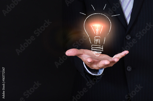 businessman holding a sketch lightbulb