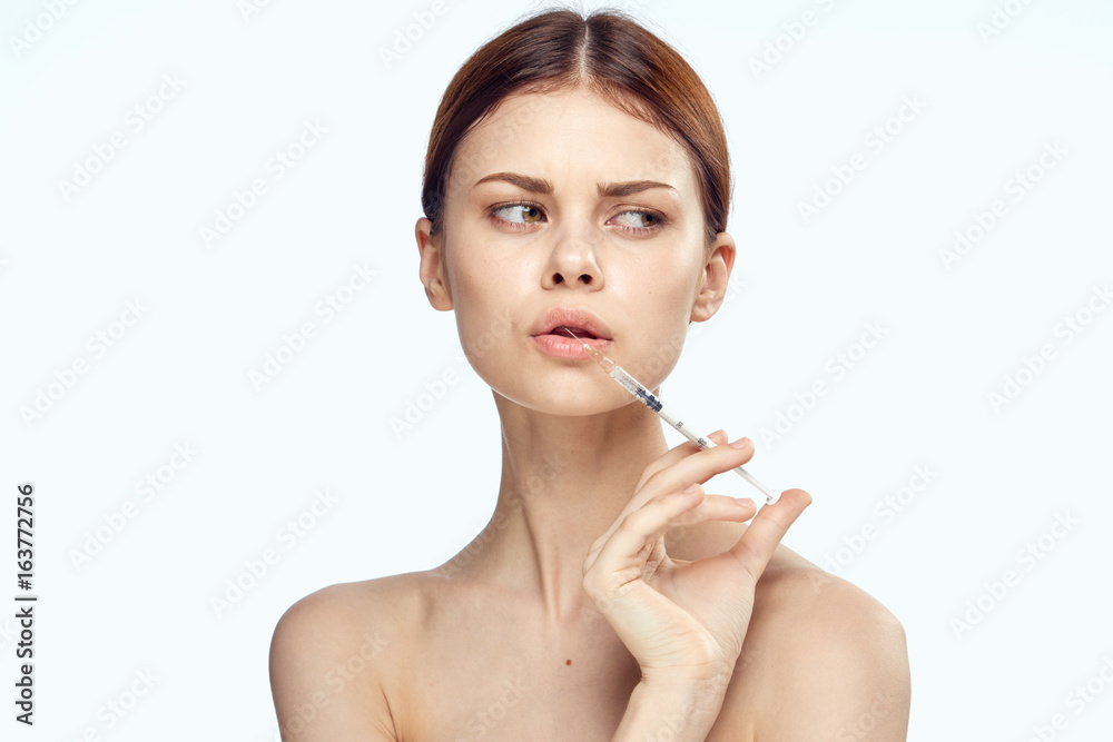 Young beautiful woman on white isolated background holds a syringe, medicine, nurse Young beautiful woman on white isolated background holds a syringe, medicine, nurse