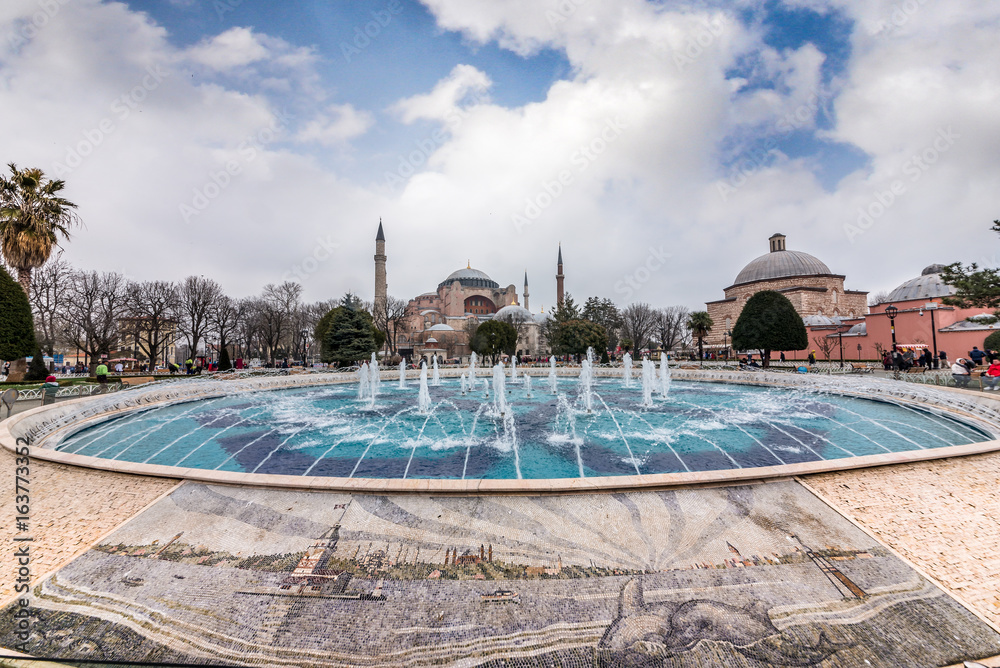 Naklejka premium Sultanahmet Park z widokiem na Błękitny Meczet zwany także Sultan Ahmed Mosque lub Sultan Ahmet Mosque z fontanną na pierwszym planie, Istambuł, Turcja.