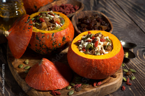 rice with dried fruit in a pumpkin on wooden table