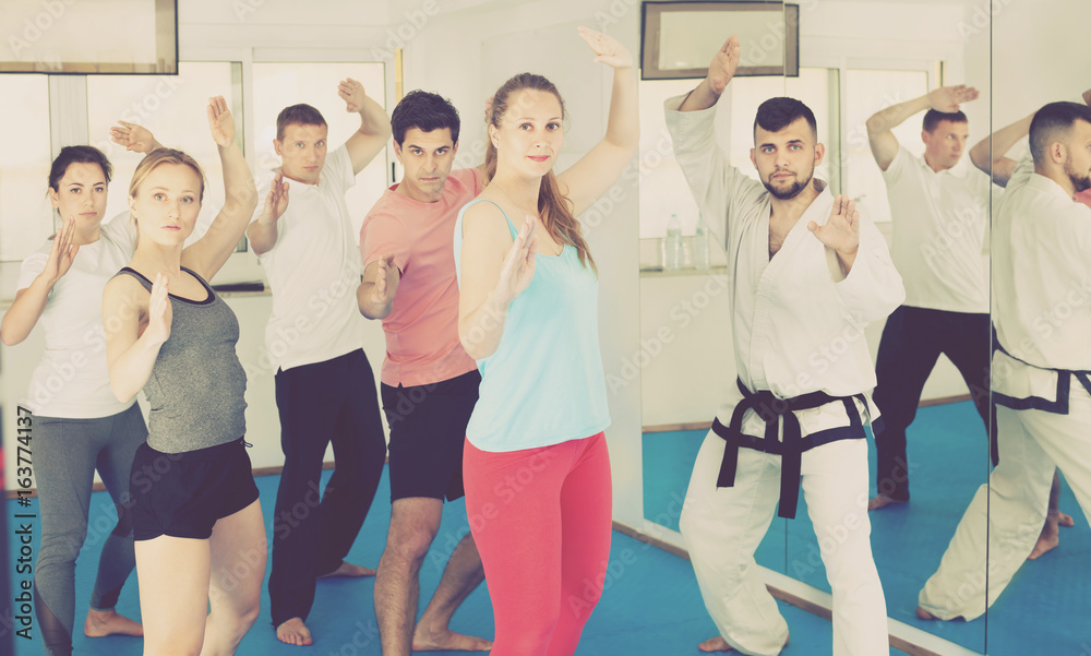Fototapeta premium Young adult trainees practicing in karate class