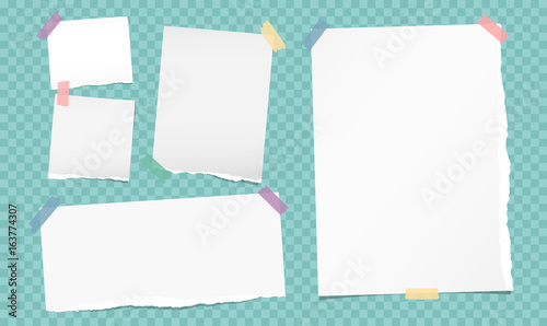 White note, notebook, copybook paper strips stuck with colorful sticky tape on turquoise squared background.