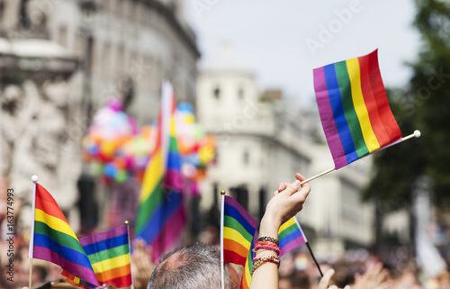 A spectator waves a gay rainbow flag at an LGBT gay pride march in London
