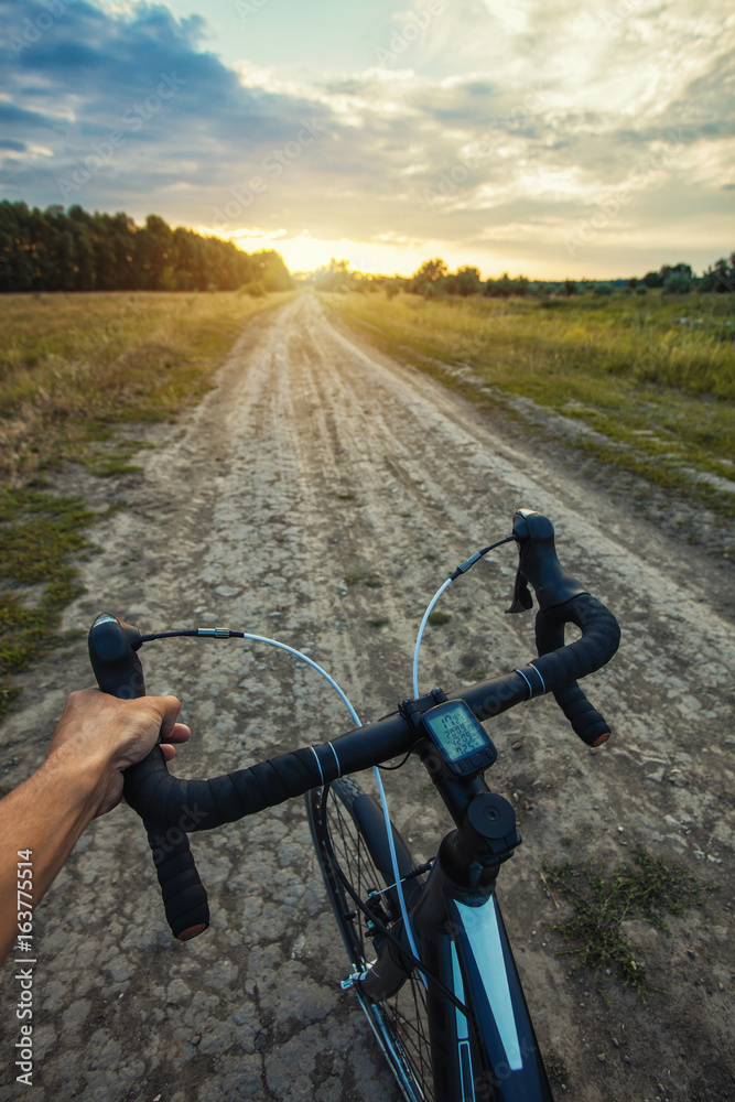 cyclist rides on the meadov dirt road on a Cyclocross bike. cyclist rides on the meadov dirt road on a Cyclocross bike.