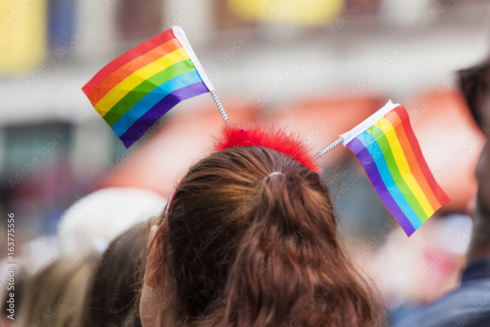 Person wears a gay rainbow flag headband at an LGBT gay pride march in  London Stock Photo | Adobe Stock