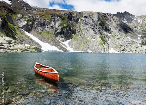 Tableau sur toile Wooden canoe in the middle of the water