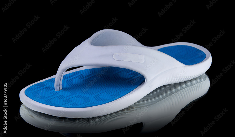 Male White and Blue Slipper on Black Background, Isolated Product, Top View, Studio. Male White and Blue Slipper on Black Background, Isolated Product, Top View, Studio.
