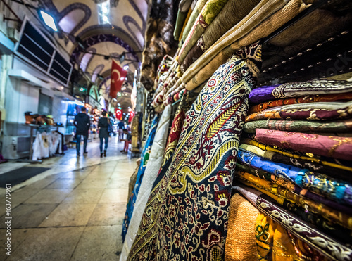 ISTANBUL, TURKEY- APRIL 17, 2017: Unidentified Tourists visiting and shopping in the Grand Bazaar in Istanbul. Interior of the Grand Bazaar with souvenirs on the foreground