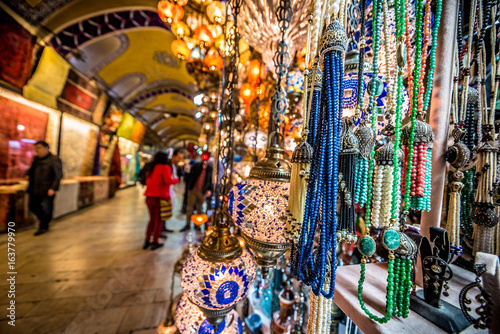 ISTANBUL, TURKEY- APRIL 17, 2017: Unidentified Tourists visiting and shopping in the Grand Bazaar in Istanbul. Interior of the Grand Bazaar with souvenirs on the foreground © epic_images