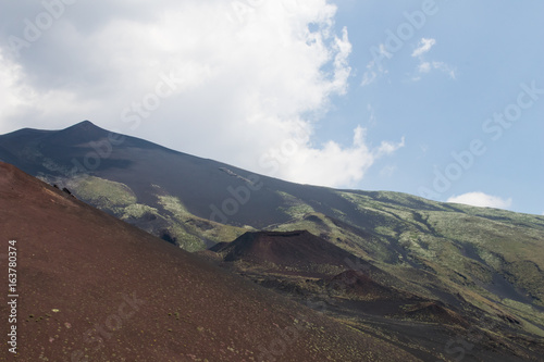 Panorama from the Etna volcano with old smaller craters and the green slopes of the volcano