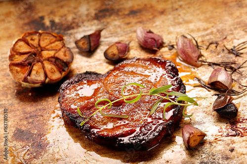 Fried grilled pork neck with garlic on rustic background