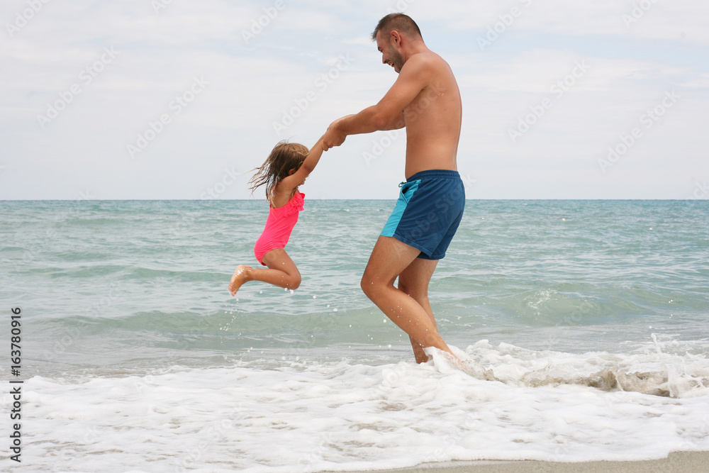 Fototapeta premium Family at the beach in the summertime.