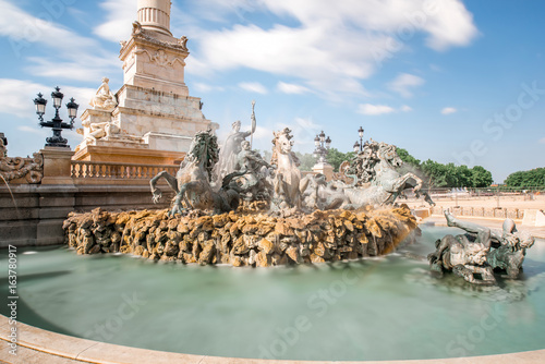 View on the Quinconces square with Girondins fountain in Bordeaux city in France. Long exposure image technic with motion blurred clouds photo