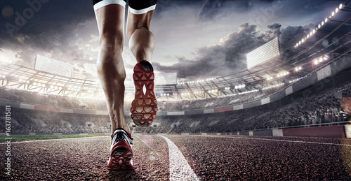 Sports background. Runner feet running on stadium closeup on shoe. Dramatic picture.