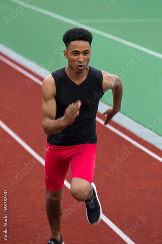 African athlete man run on running track outdoors © Drobot Dean