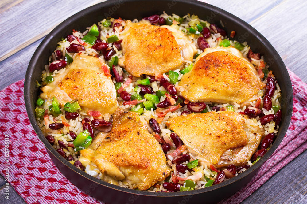 Chicken with Rice, Beans, Bacon and Green Pepper in Pan. View from above, top studio shot Chicken with Rice, Beans, Bacon and Green Pepper in Pan. View from above, top studio shot
