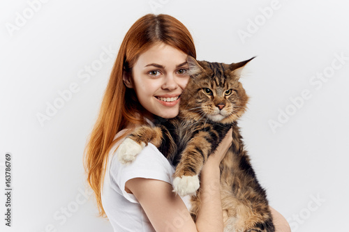 Beautiful young woman on white isolated background holds a cat