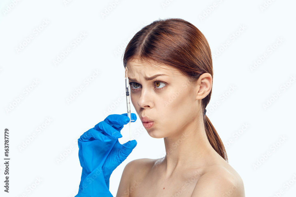 Young beautiful woman on white isolated background holds a syringe, medicine, nurse
