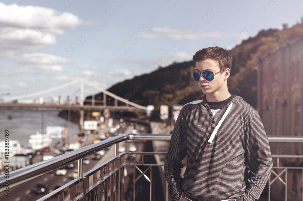 young man on a bridge in a big city young man on a bridge in a big city