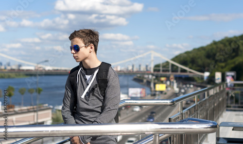 young man on a bridge in a big city