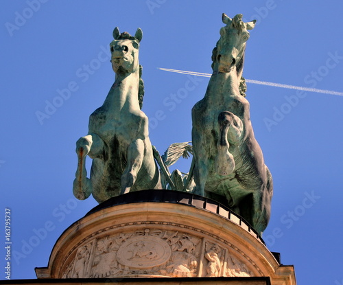 Pferde vor dem Streitwagen auf der Kolonnade des Heldenplatzes vor strahlend blauem Himmel mit weißem Kondensstreifen