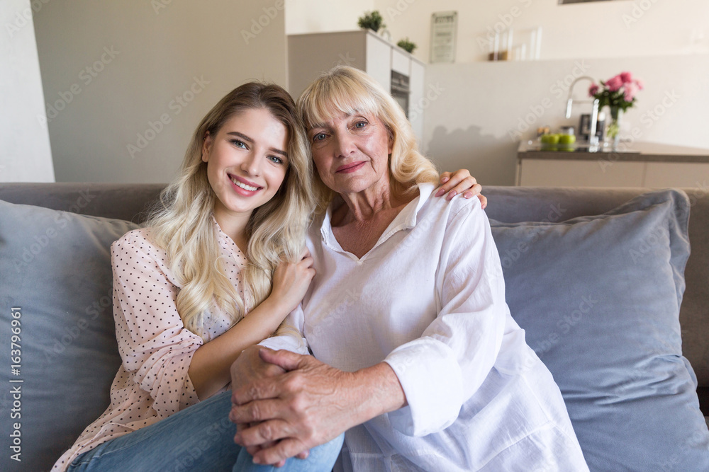 Smiling granddaughter and grandmother sitting together Smiling granddaughter and grandmother sitting together