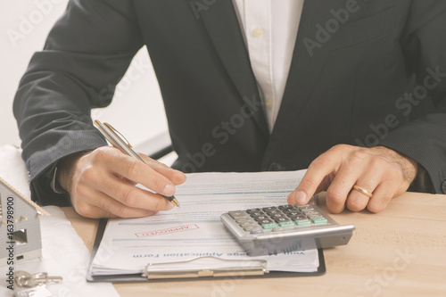  Businessman signing a mortgage contract of a sale for a new house