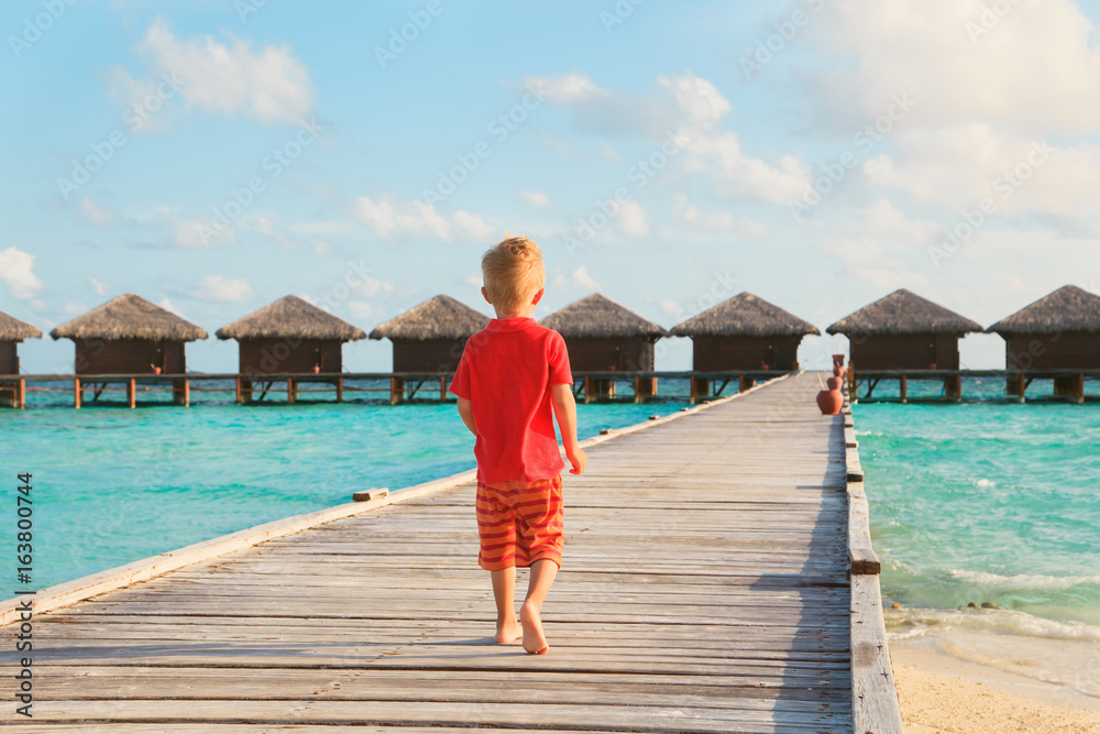 little boy walking on beach resort