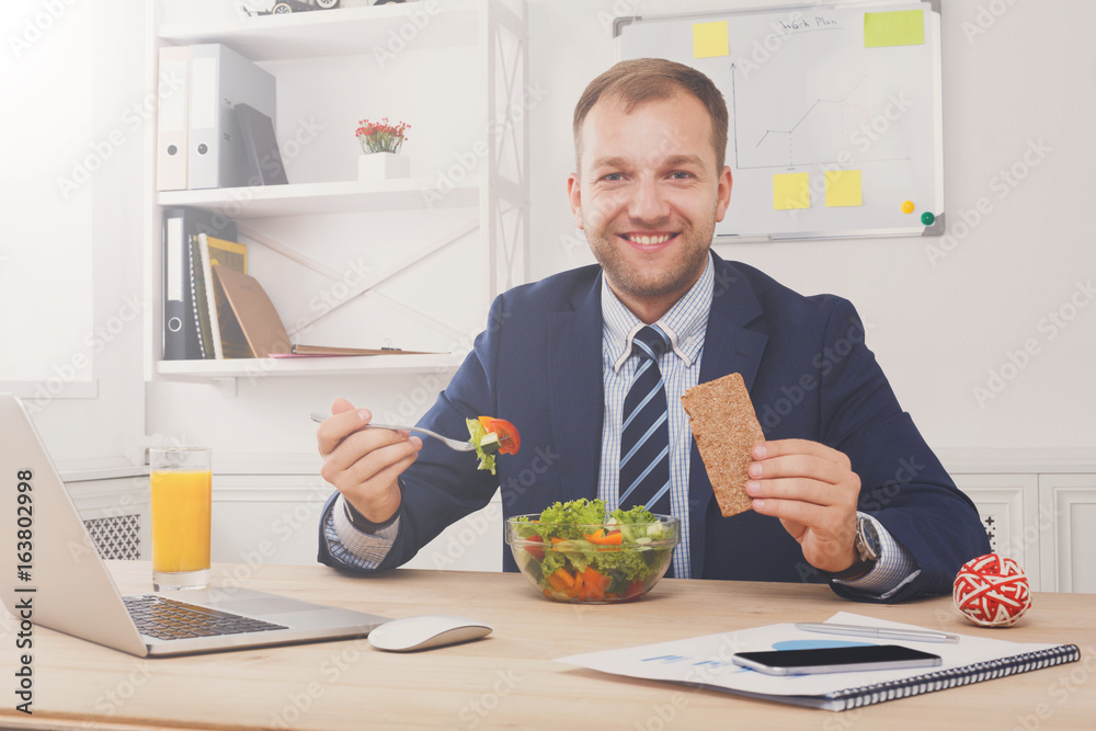 Man has healthy business lunch in modern office interior Man has healthy business lunch in modern office interior
