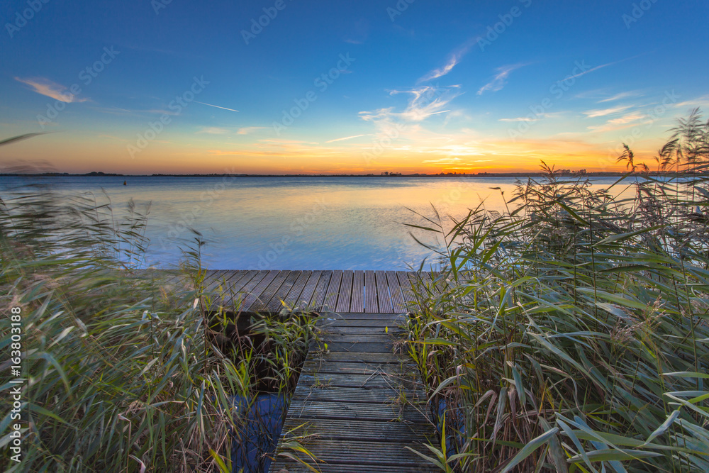 Long Exposure Image of Sunset over Boardwalk on the shore of a Lake