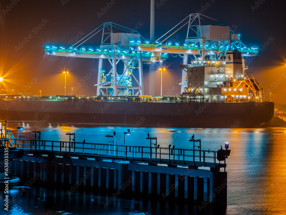 Obraz premium Ship unloading coal in a harbor