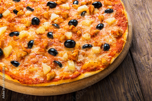 Delicious pizza with pineapples and black olives