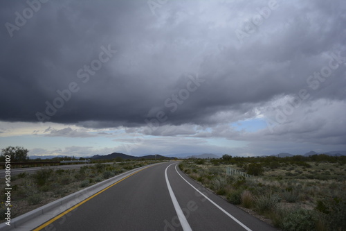 Dark storm clouds over rural countryside with mountains and open land