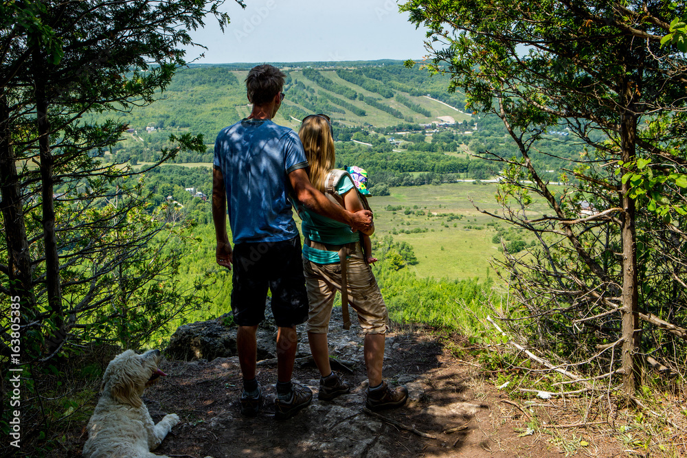 Young family hiking with their dog and their newborn Young family hiking with their dog and their newborn