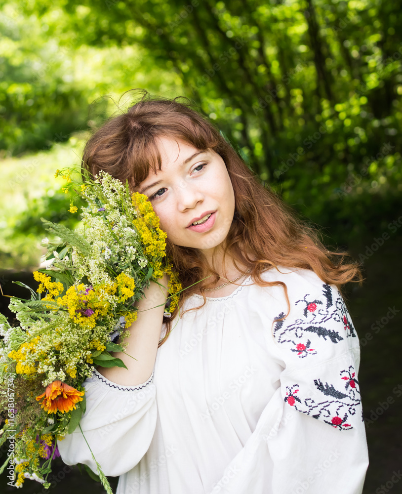 Pretty young woman in traditional dress with a wreath of wild flowers. Pretty young woman in traditional dress with a wreath of wild flowers.