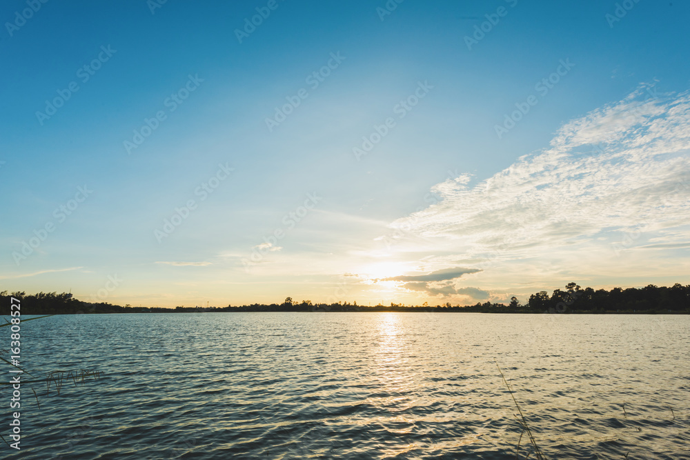 Fototapeta premium Beautiful sunset landscape with blue sky over lake