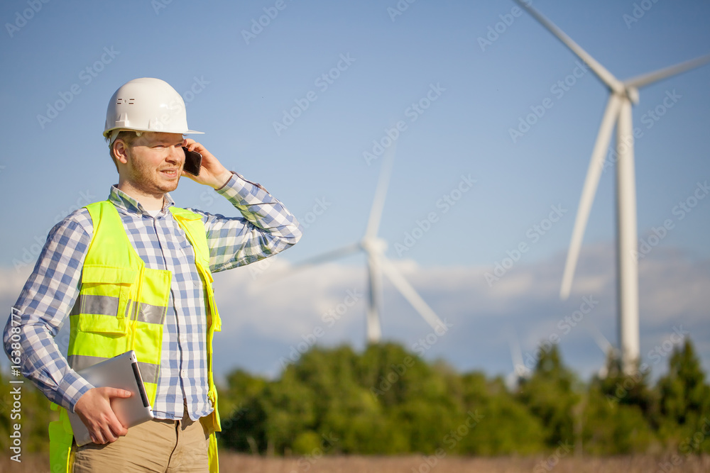 young engineer is checking on wind turbine energy production young engineer is checking on wind turbine energy production