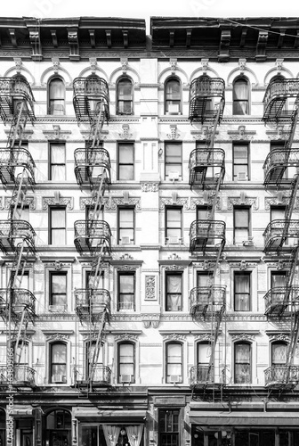 New York City vintage apartment building with windows and fire escapes in black and white