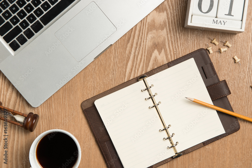 Business planning concept. Top view of hand writing on a blank notebook with hot coffee. Business planning concept. Top view of hand writing on a blank notebook with hot coffee.