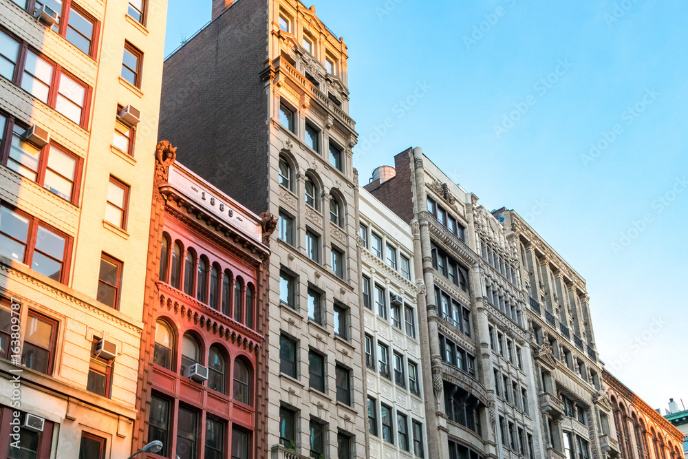 Row of tall historic buildings in the afternoon sunlight along Broadway in Manhattan, New York City