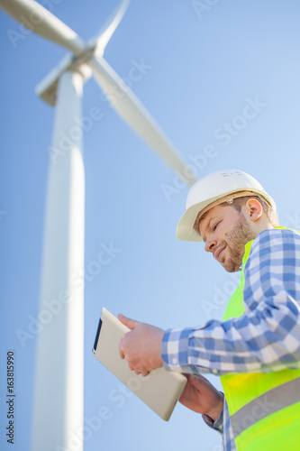 young engineer is checking on wind turbine energy production
